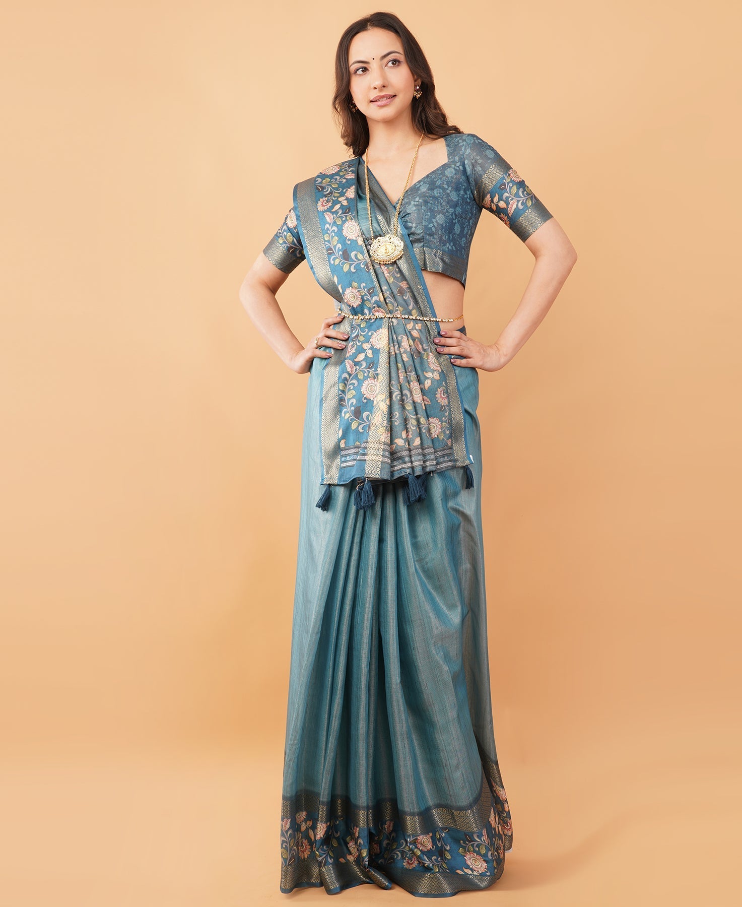 Teal blue textured saree with Kalamkari floral border and tassel pallu