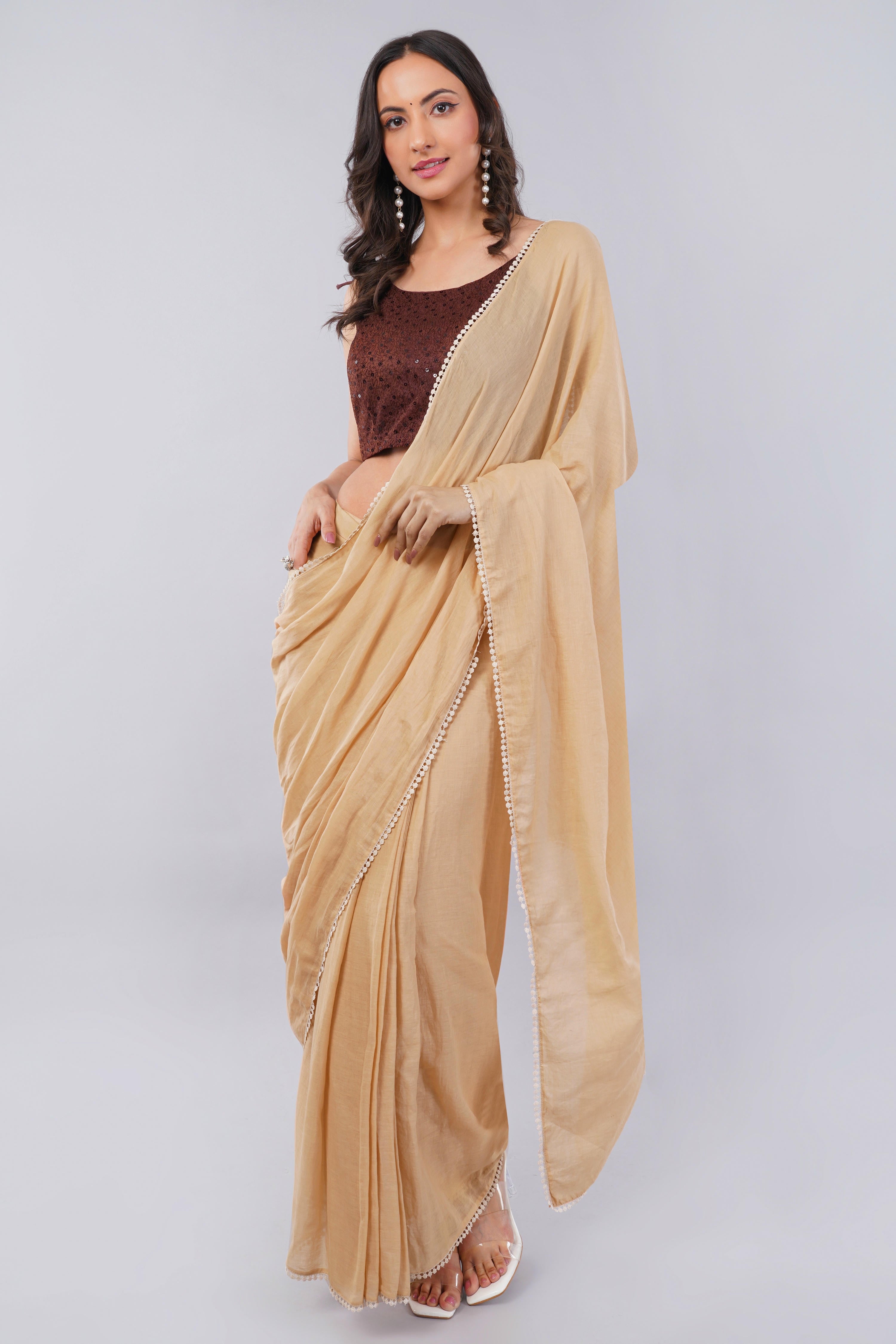 Beige ready-to-wear saree with pocket, white lace border and dark brown sleeveless blouse