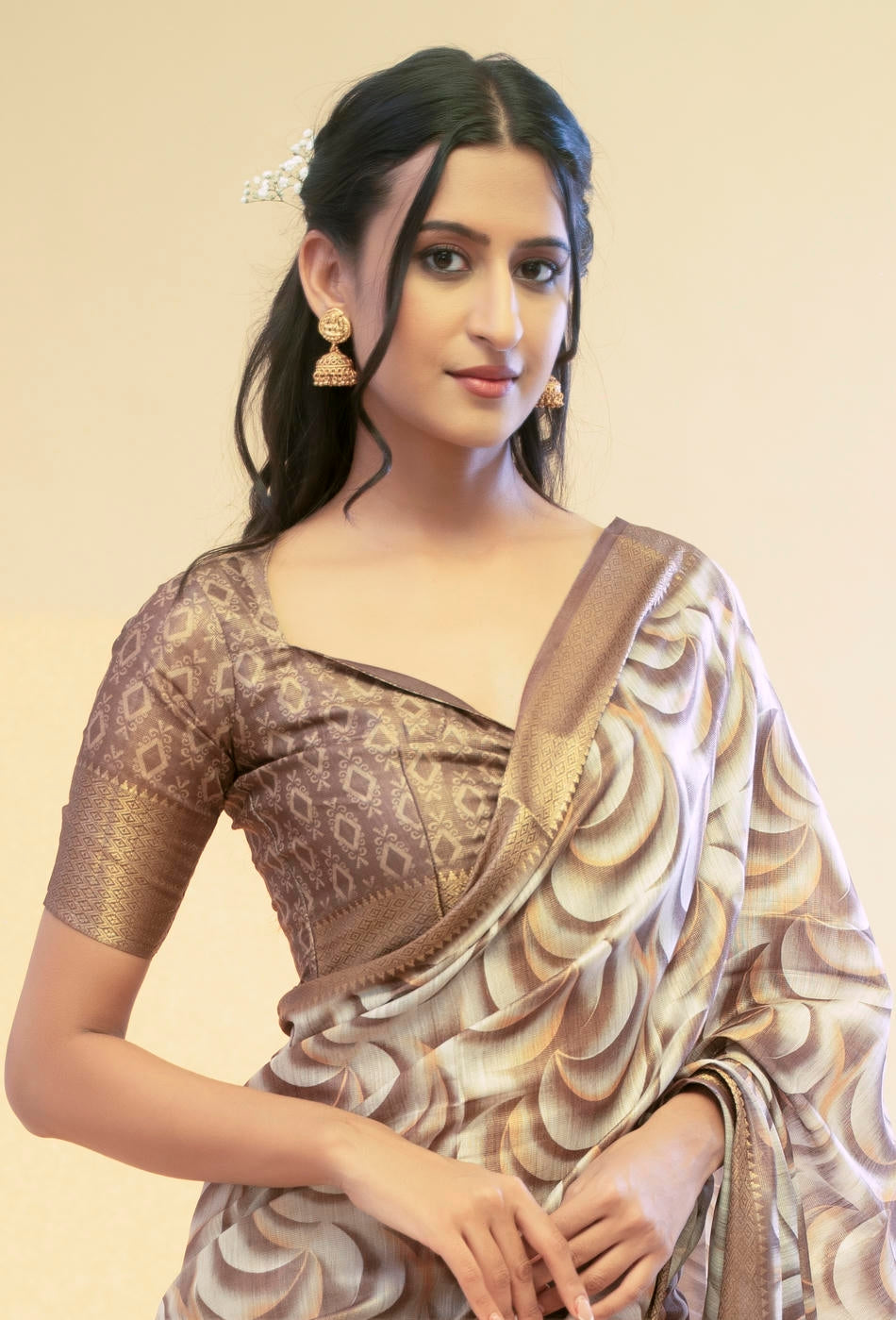 Bronze and cream abstract wave print saree with antique gold zari border and tassel pallu