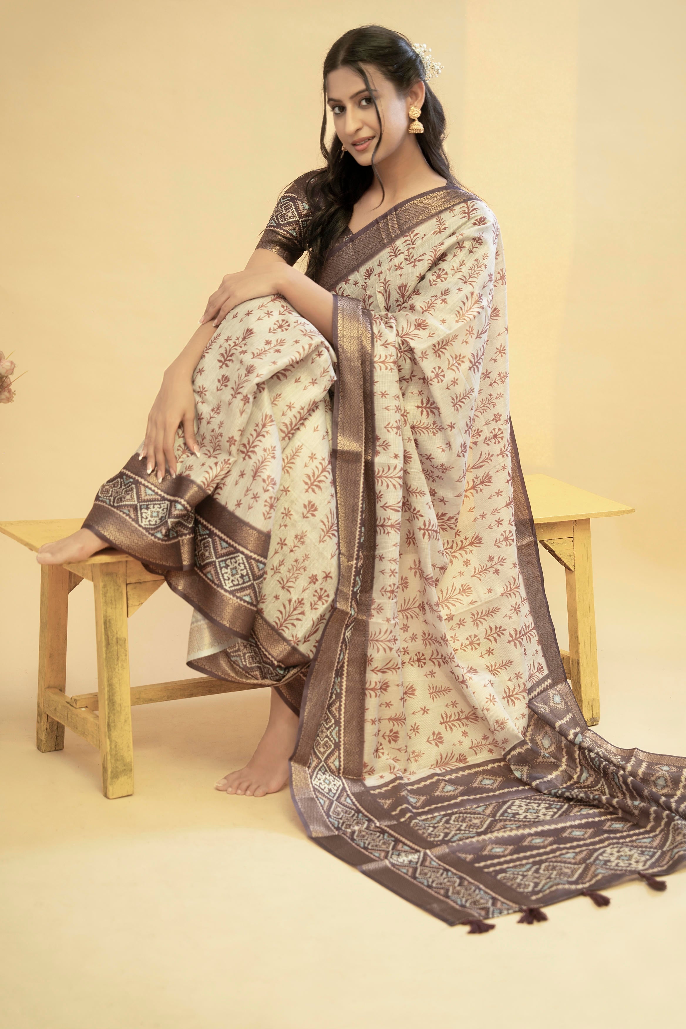 Cream terracotta floral vine saree with dark brown zari border and tassel pallu