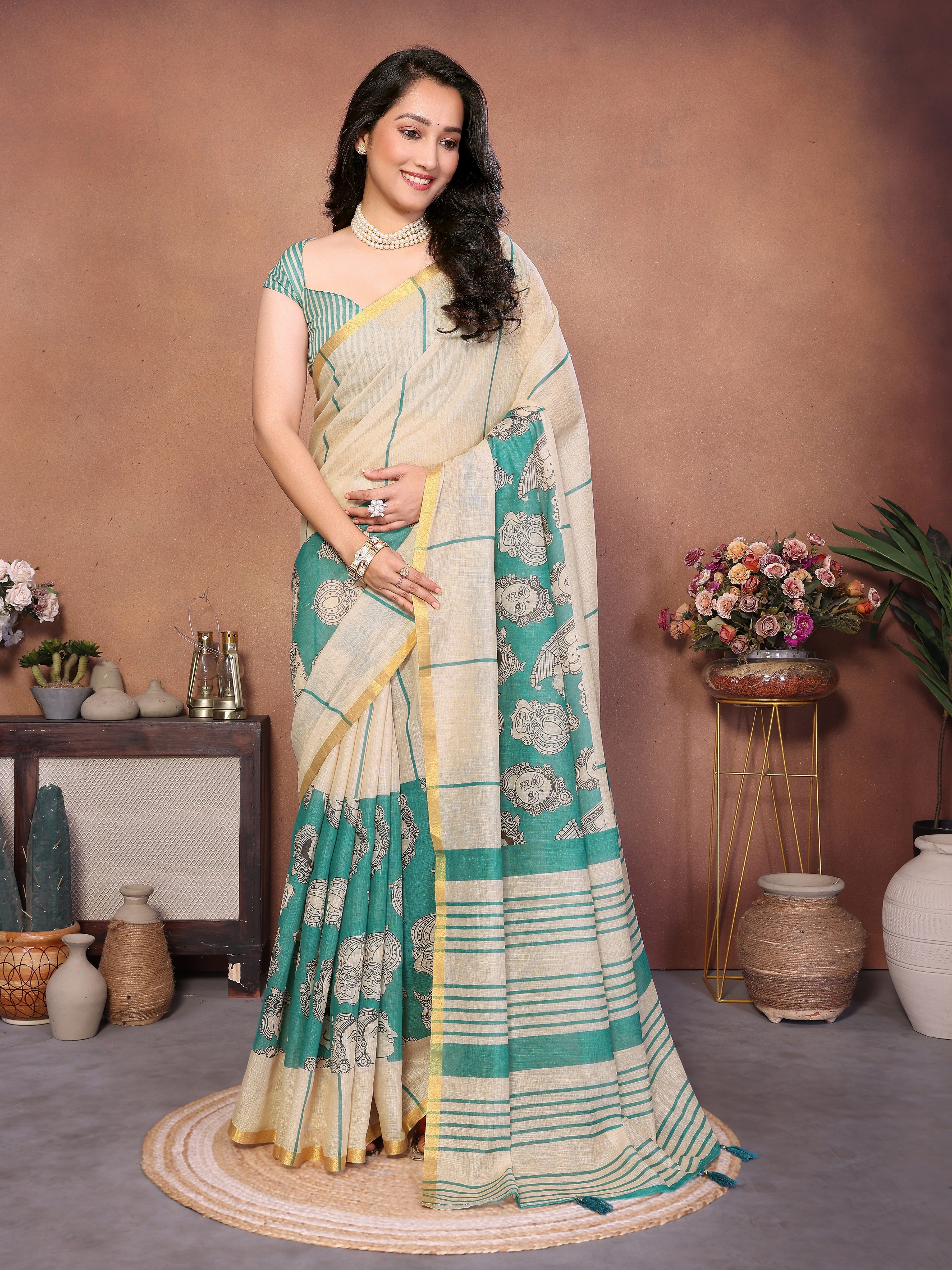 Cream and sea-green Kathakali print linen-look saree with gold zari border and striped pallu