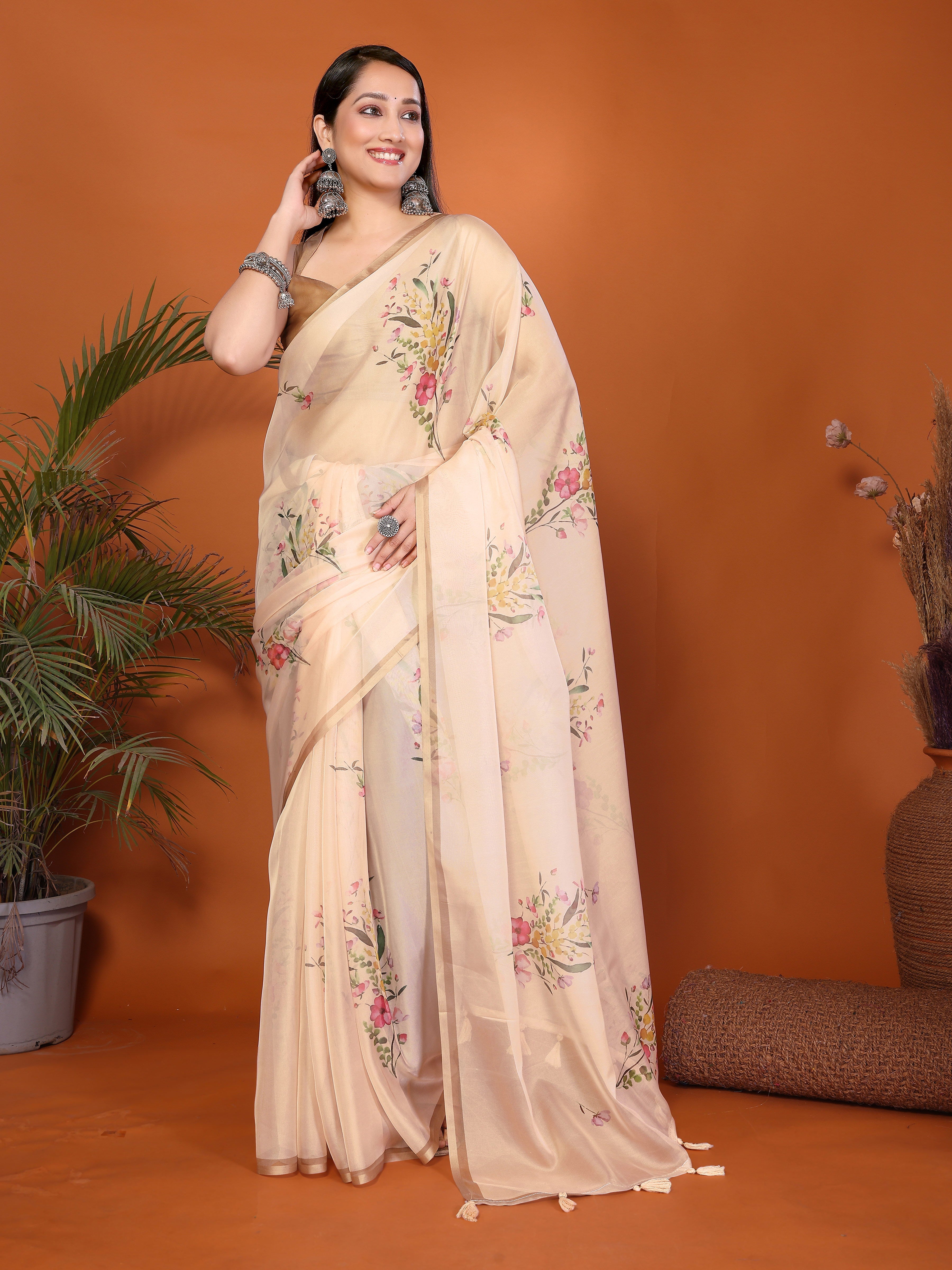 Sandalwood peach floral print saree with metallic border, tassel pallu and ruched bronze sleeveless blouse