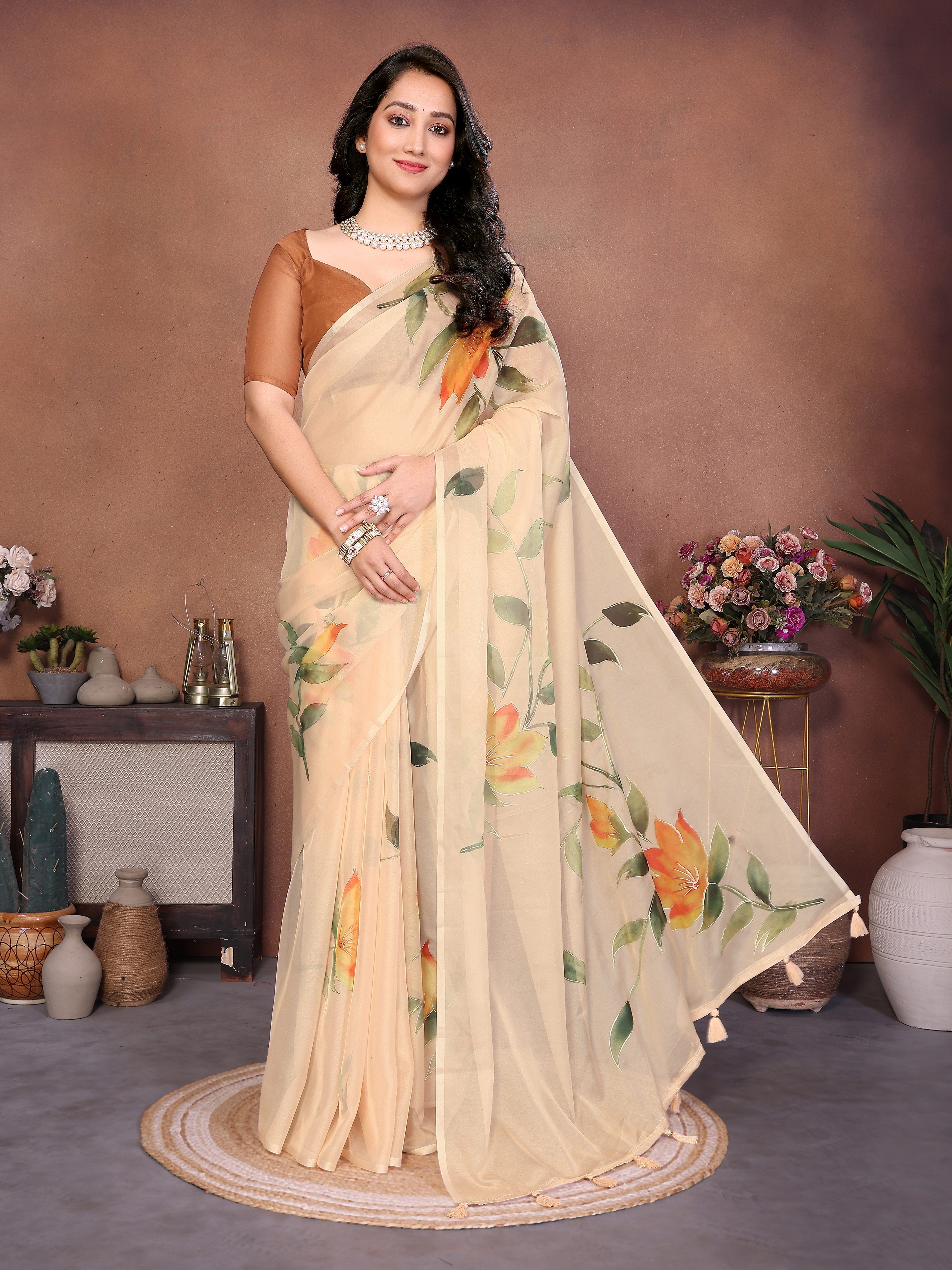 Cream floral print saree with orange lily motifs, gold border and bronze ruched blouse